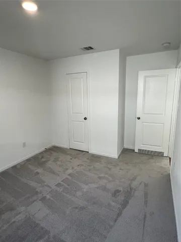 an empty room with windows and closet