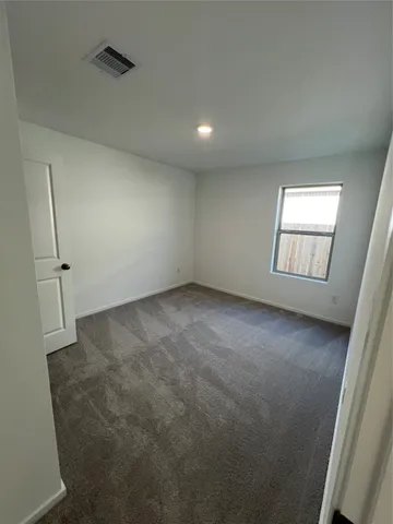 an empty room with yellow lighting and windows