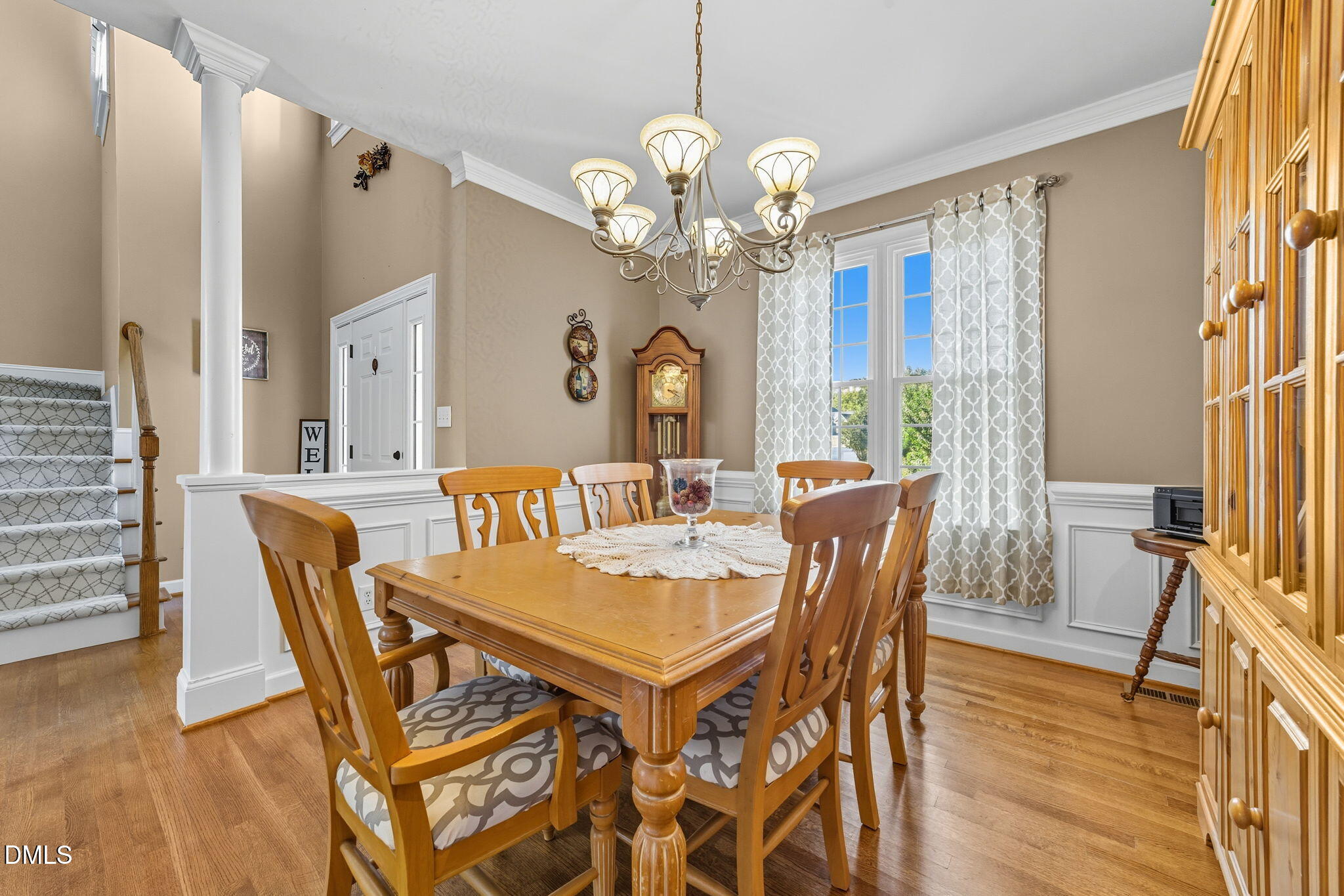 1617 Kendall Hill Road Willow Spring, NC 27592 - Photo 32 of 58 a dining room with wooden floor a chandelier a wooden table and chairs