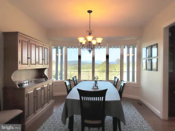 a view of a dining room with furniture a chandelier and wooden floor