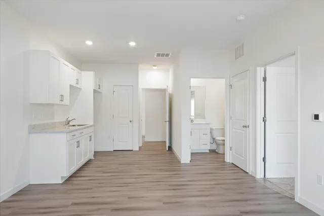 a view of a kitchen with wooden floor and electronic appliances