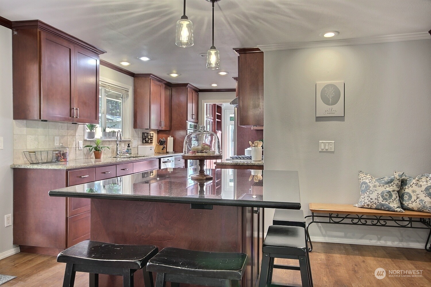 16613 Southeast 145th Street Renton, WA 98059 - Photo 13 of 40 a kitchen with kitchen island granite countertop a table chairs sink and cabinets