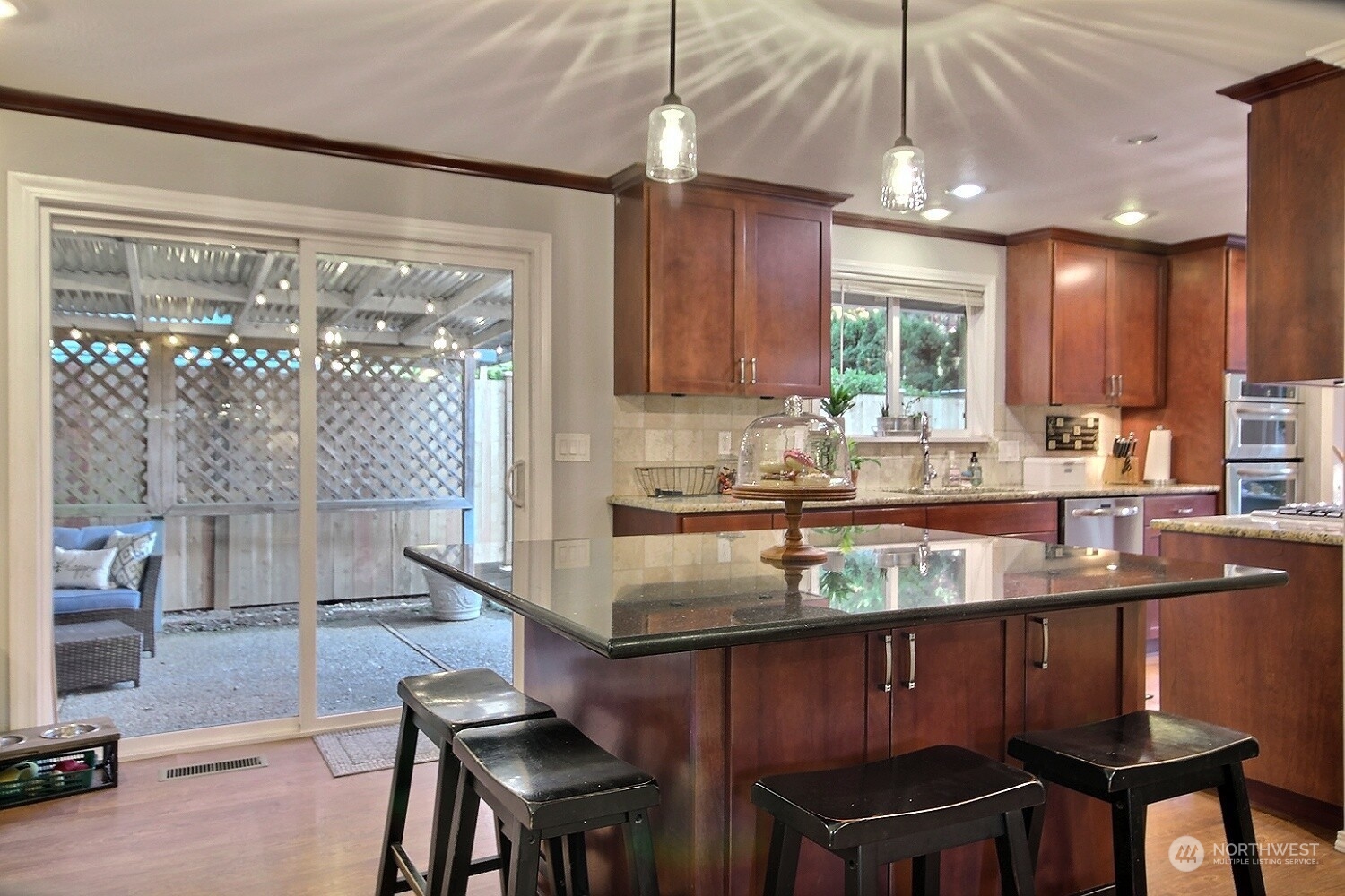 16613 Southeast 145th Street Renton, WA 98059 - Photo 15 of 40 a kitchen with kitchen island granite countertop a table chairs stove and a sink