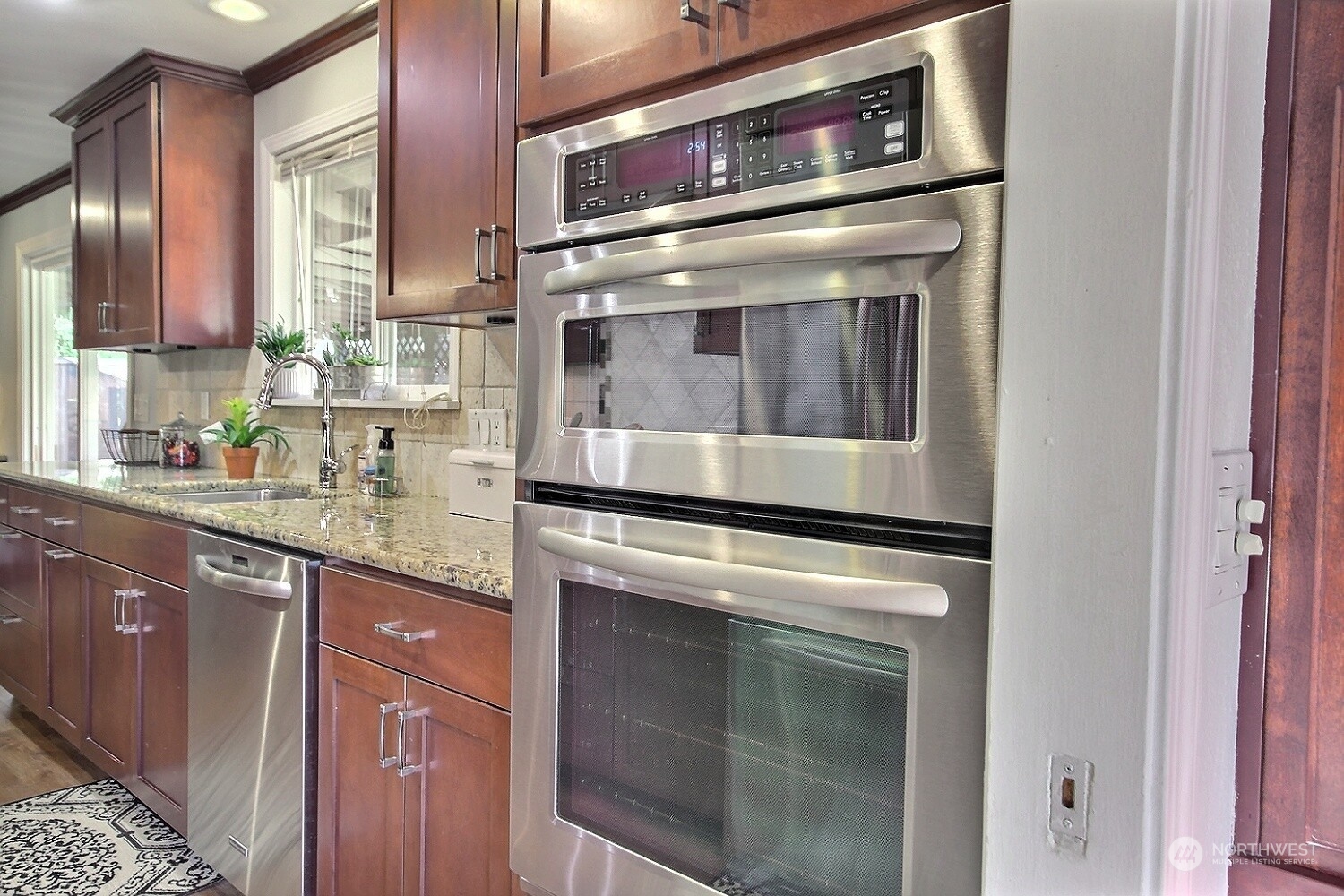 16613 Southeast 145th Street Renton, WA 98059 - Photo 19 of 40 a kitchen with stainless steel appliances granite countertop a stove and a microwave