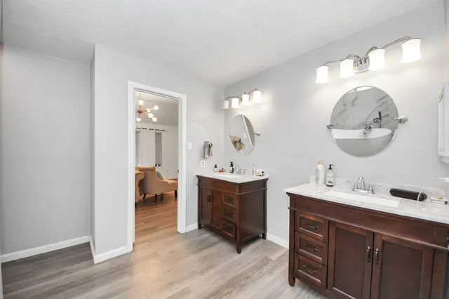 a en suite bathroom with a double vanity sink and a mirror