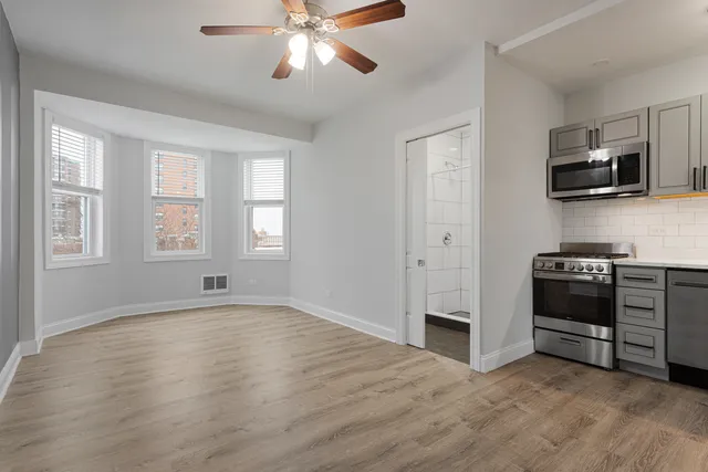 a view of kitchen with microwave stove and refrigerator
