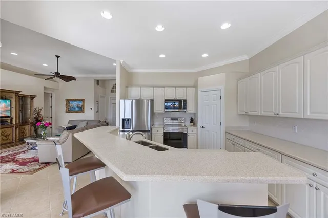 a kitchen with stainless steel appliances kitchen island granite countertop a refrigerator and a sink