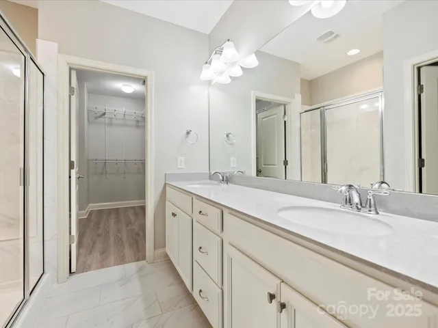 a spacious bathroom with a double vanity sink mirror and shower