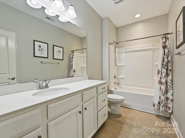 a bathroom with a double vanity sink mirror and toilet