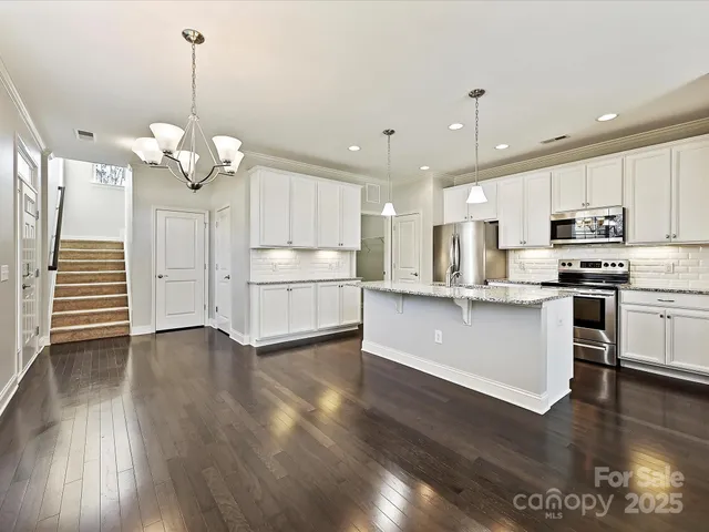 a view of a kitchen with stove and wooden floor