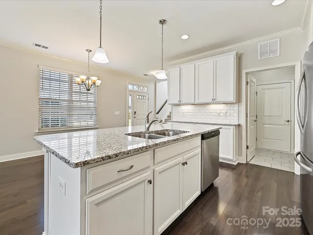 a kitchen with granite countertop a sink cabinets and window