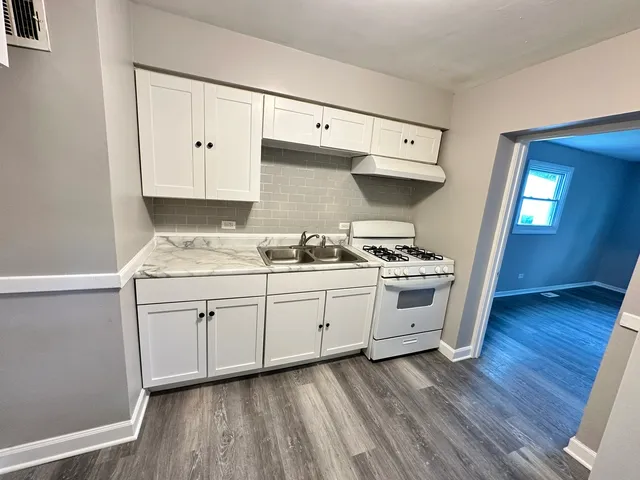 a kitchen with granite countertop white cabinets and white appliances