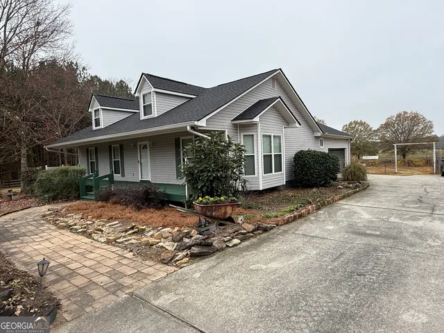 a view of a house with a yard and large tree