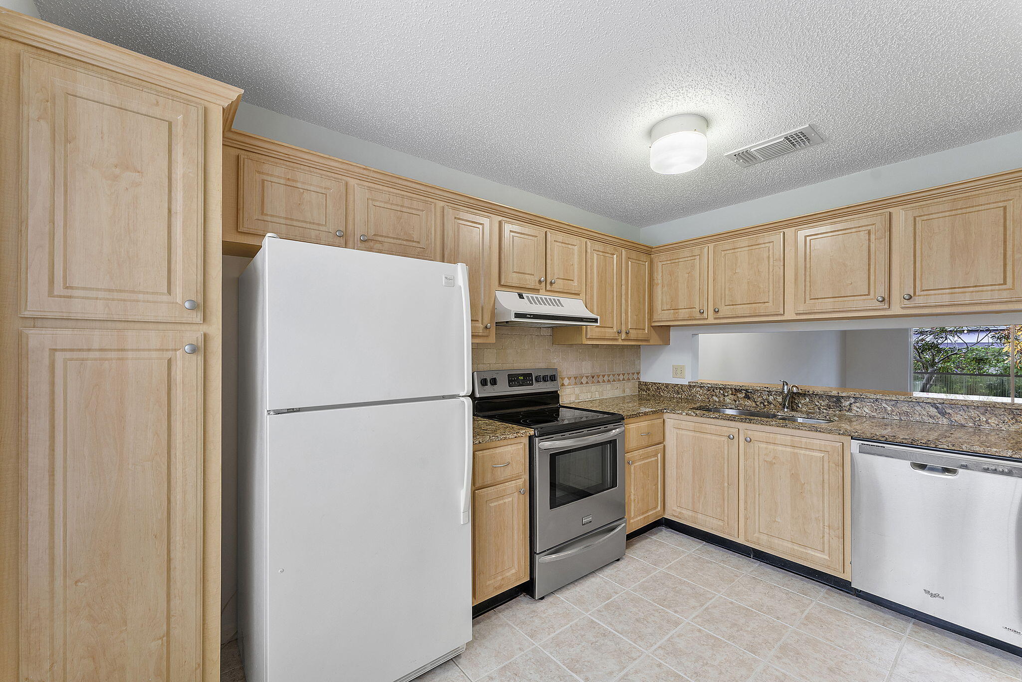 115 Oakwood Drive Jupiter, FL 33458 - Photo 6 of 21 a white refrigerator freezer sitting in a kitchen