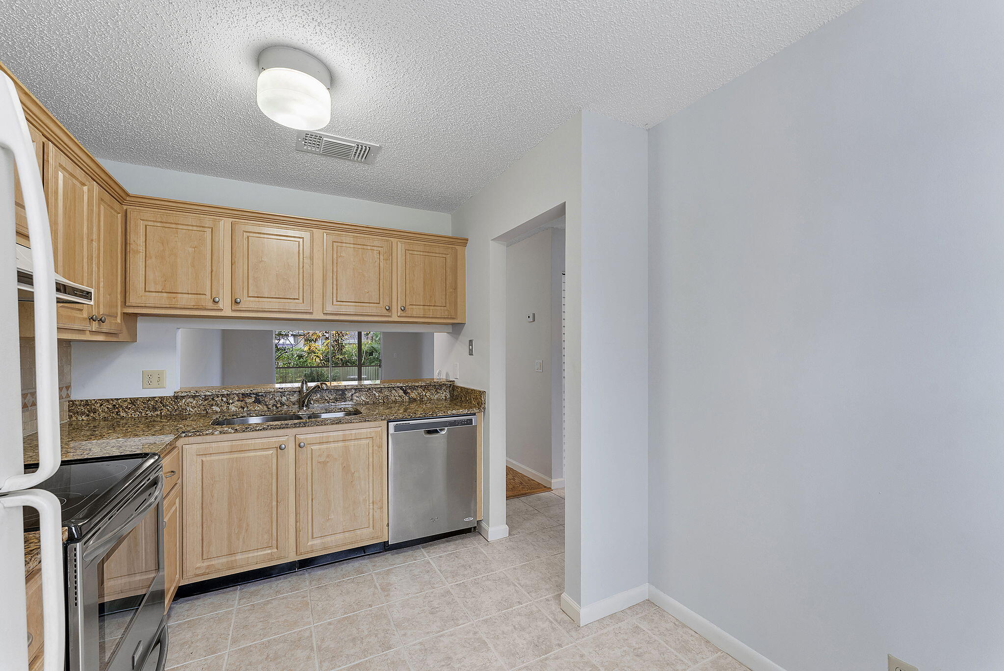 115 Oakwood Drive Jupiter, FL 33458 - Photo 7 of 21 a kitchen with stainless steel appliances granite countertop a sink and cabinets