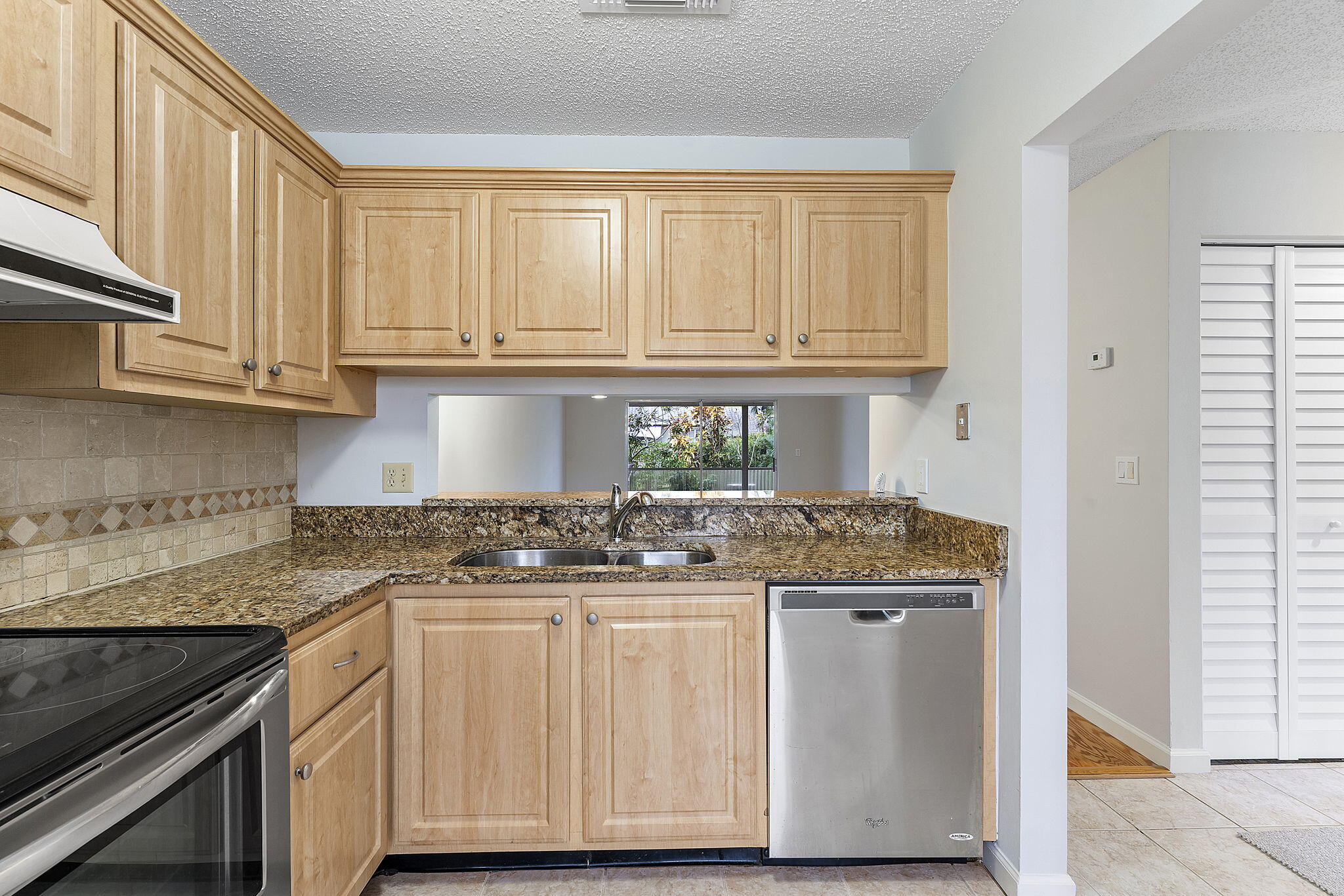 115 Oakwood Drive Jupiter, FL 33458 - Photo 8 of 21 a kitchen with stainless steel appliances granite countertop a stove and a white cabinets