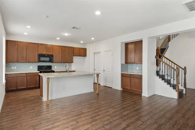 a kitchen with a refrigerator and a stove top oven
