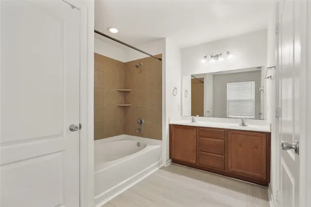 a bathroom with a bathtub shower and sink
