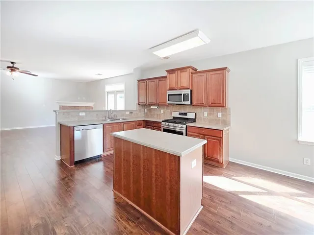 a kitchen with a sink a stove top oven and wooden floor