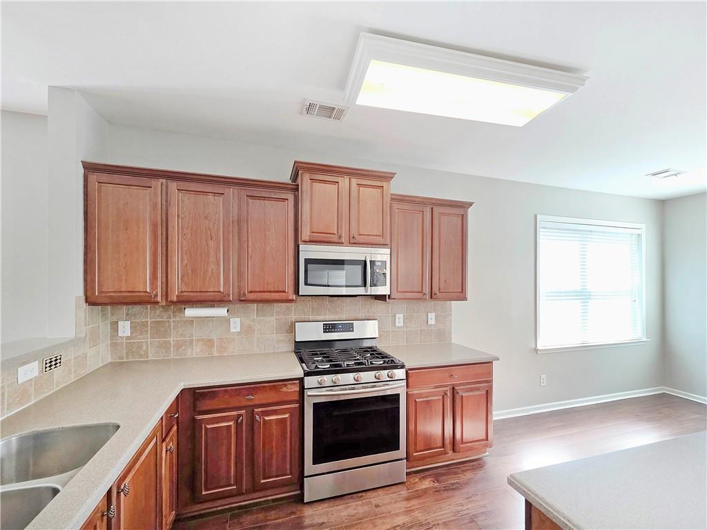 5425 Fieldfreen Drive Cumming, GA 30028 - Photo 14 of 51 a kitchen with stainless steel appliances granite countertop a sink stove and refrigerator