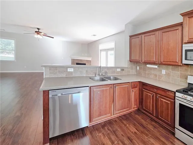 a kitchen with stainless steel appliances granite countertop a sink stove and cabinets
