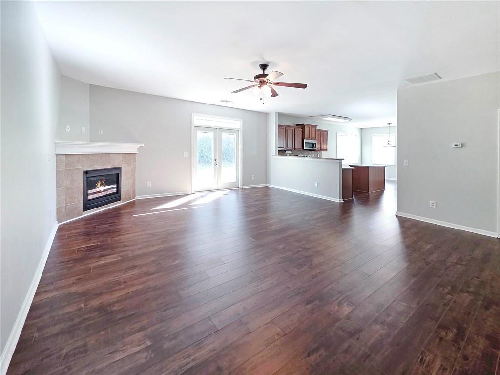 5425 Fieldfreen Drive Cumming, GA 30028 - Photo 21 of 51 a view of a livingroom with a ceiling fan a fireplace and wooden floor