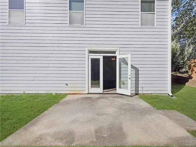 a view of a white house with a small yard and a large windows