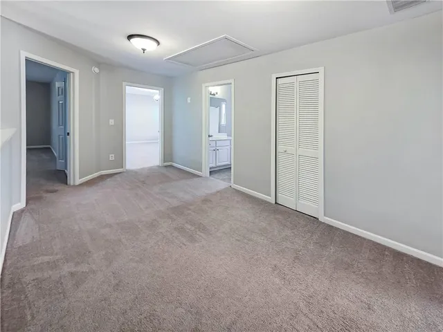 an empty room with closet and a bathroom
