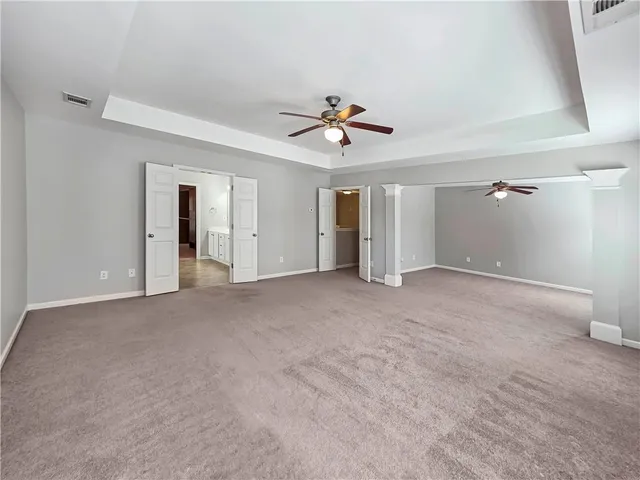 a view of a big room with chandelier fan and windows