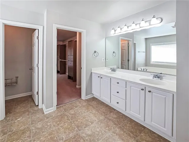 a spacious bathroom with a double vanity sink mirror and bathtub