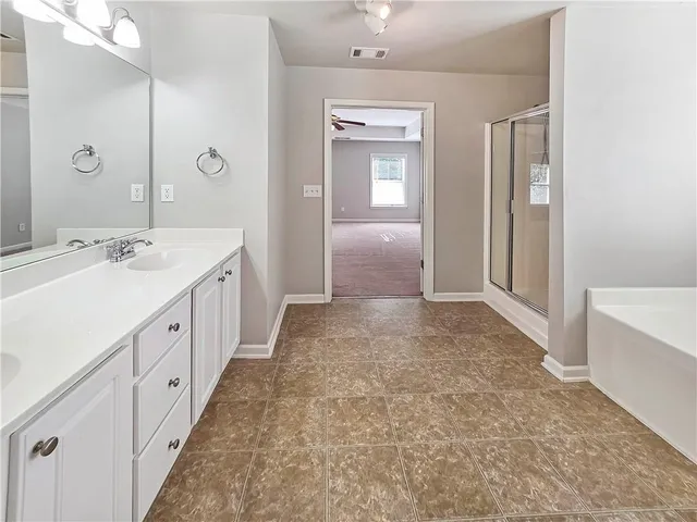 a spacious bathroom with a double vanity sink and a mirror