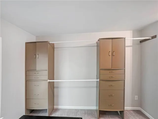 a view of walk in closet with empty racks