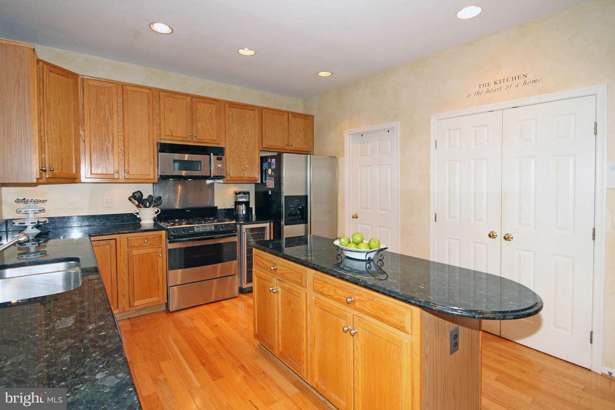 9801 Cresence Way Fairfax, VA 22032 - Photo 11 of 30 a kitchen with stainless steel appliances granite countertop a sink a stove and a refrigerator