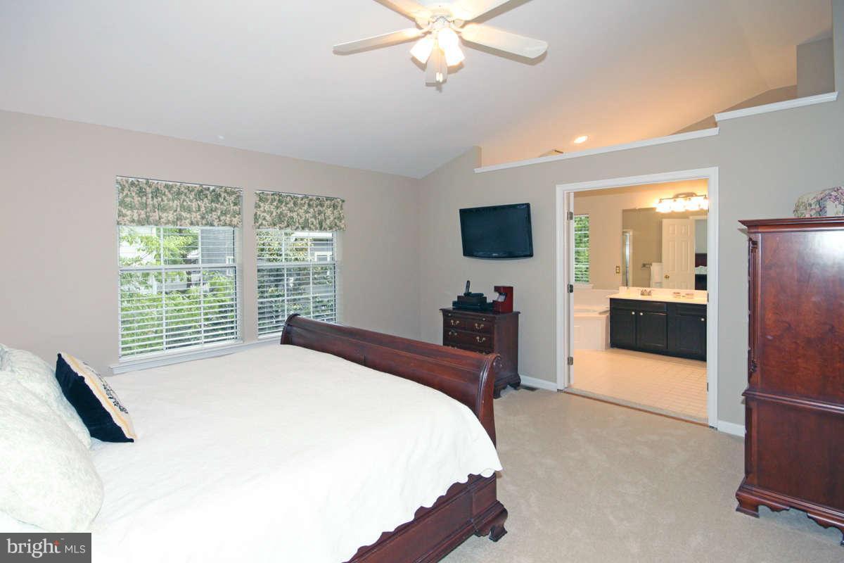 9801 Cresence Way Fairfax, VA 22032 - Photo 16 of 30 a bedroom with a large bed and a flat tv screen