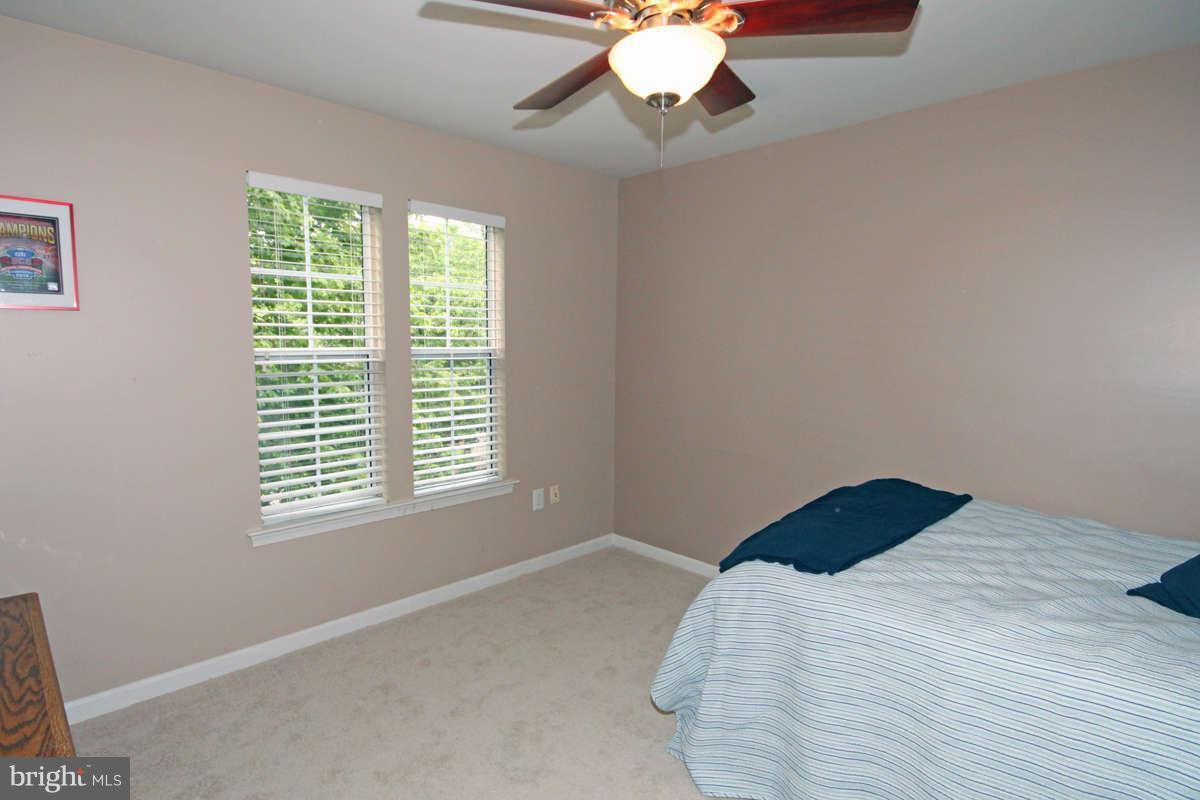9801 Cresence Way Fairfax, VA 22032 - Photo 21 of 30 a bedroom with a bed and a chandelier