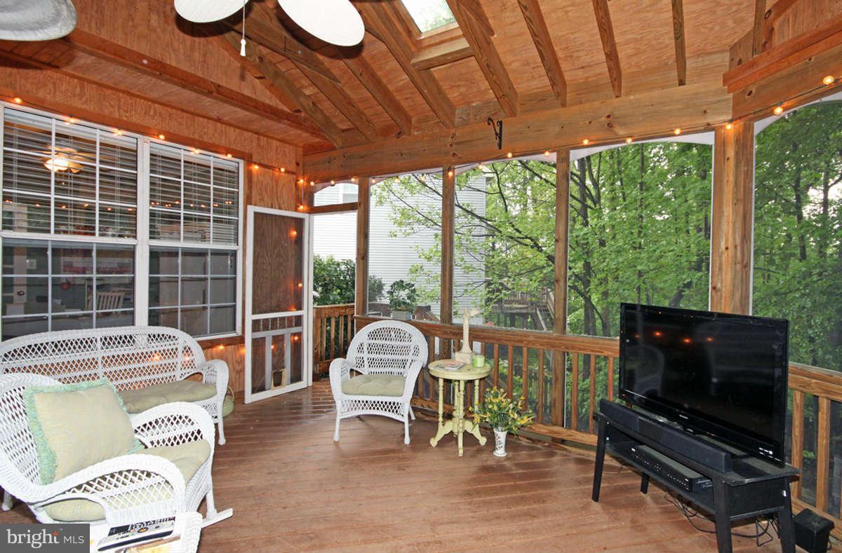 9801 Cresence Way Fairfax, VA 22032 - Photo 27 of 30 a living room with furniture a flat screen tv and a floor to ceiling window