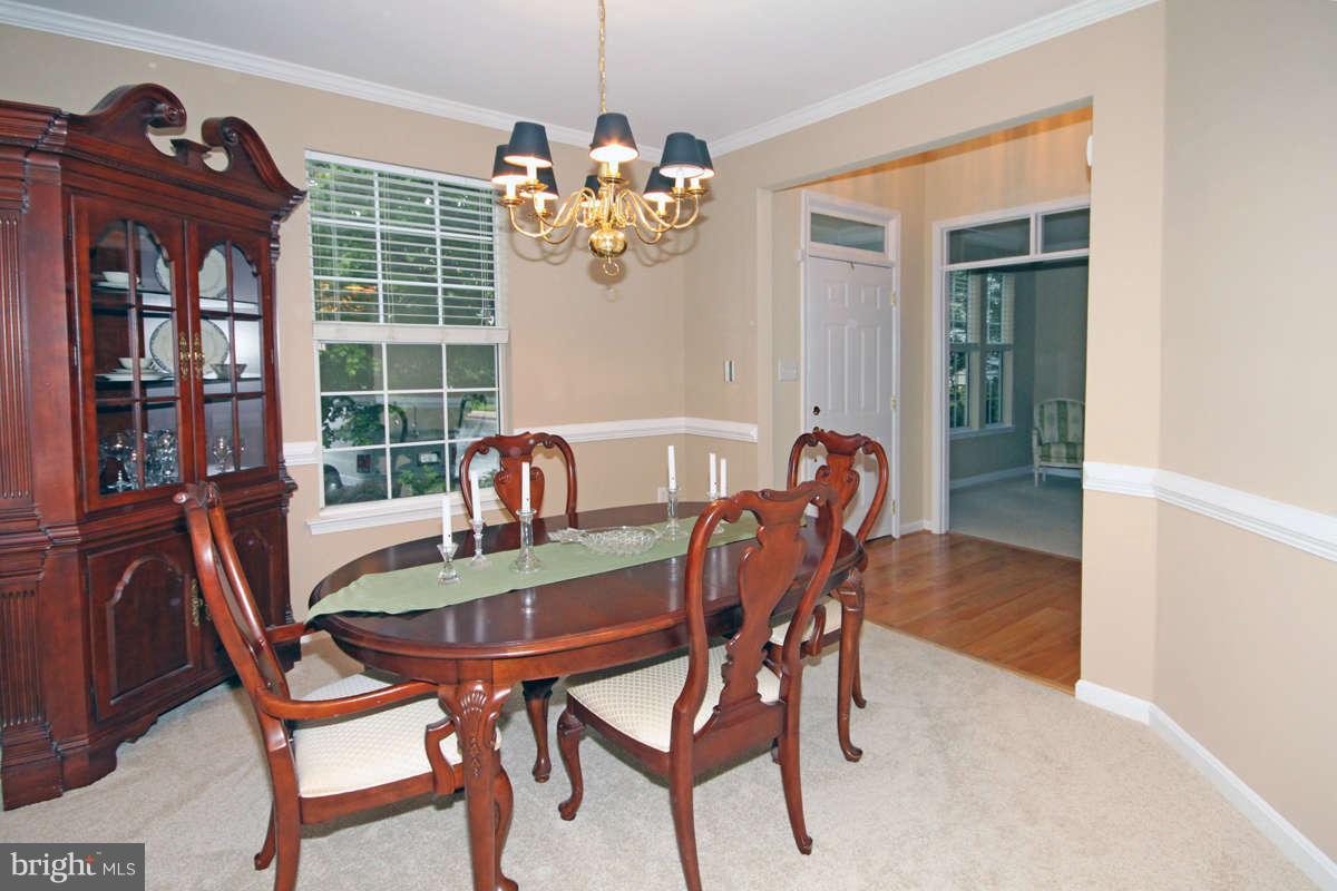 9801 Cresence Way Fairfax, VA 22032 - Photo 4 of 30 a view of a dining room with furniture wooden floor and a chandelier