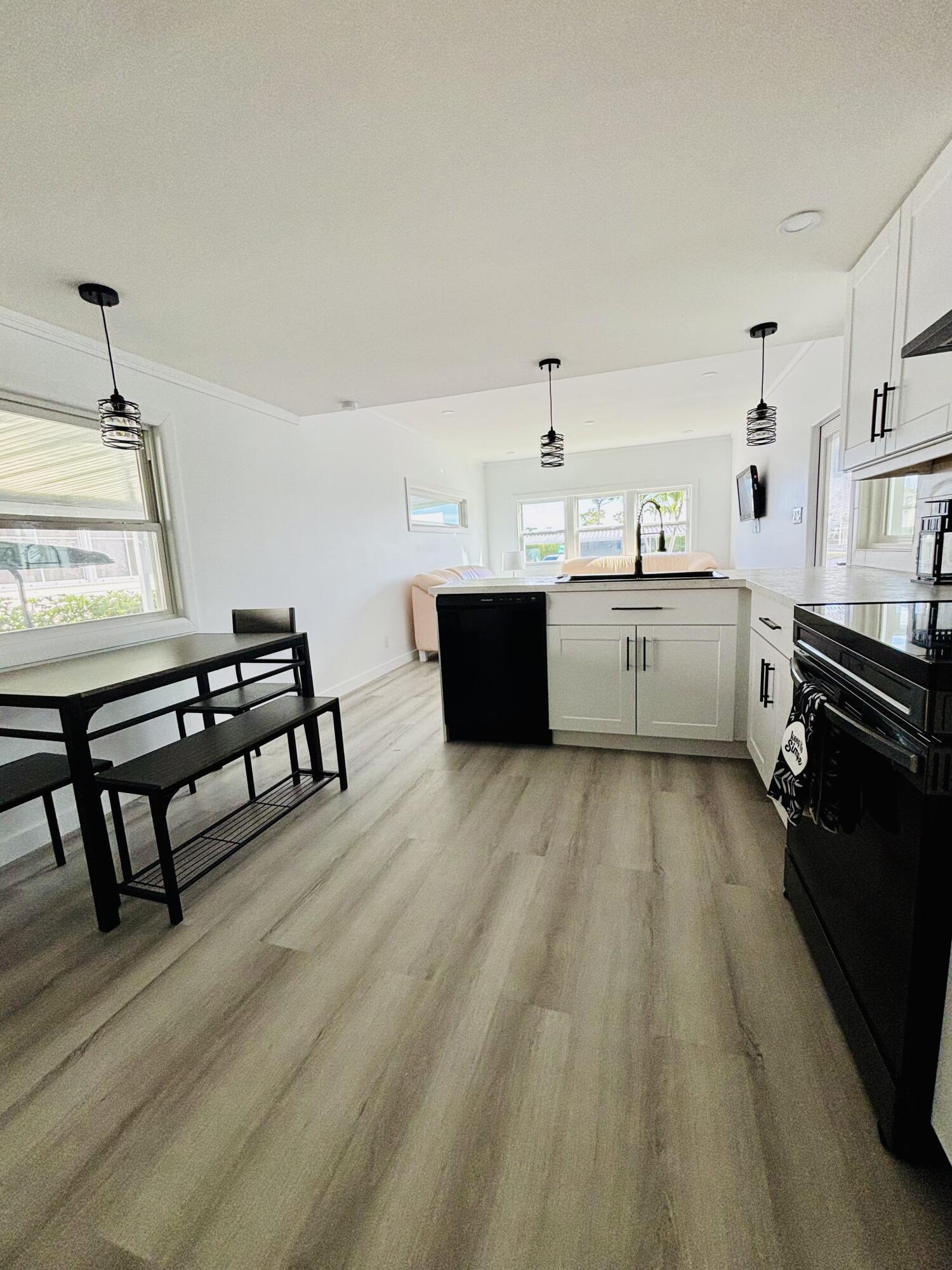 3003 Bimini Bay Boynton Beach, FL 33436 - Photo 5 of 31 a kitchen with a sink dishwasher a stove and a refrigerator with wooden floor