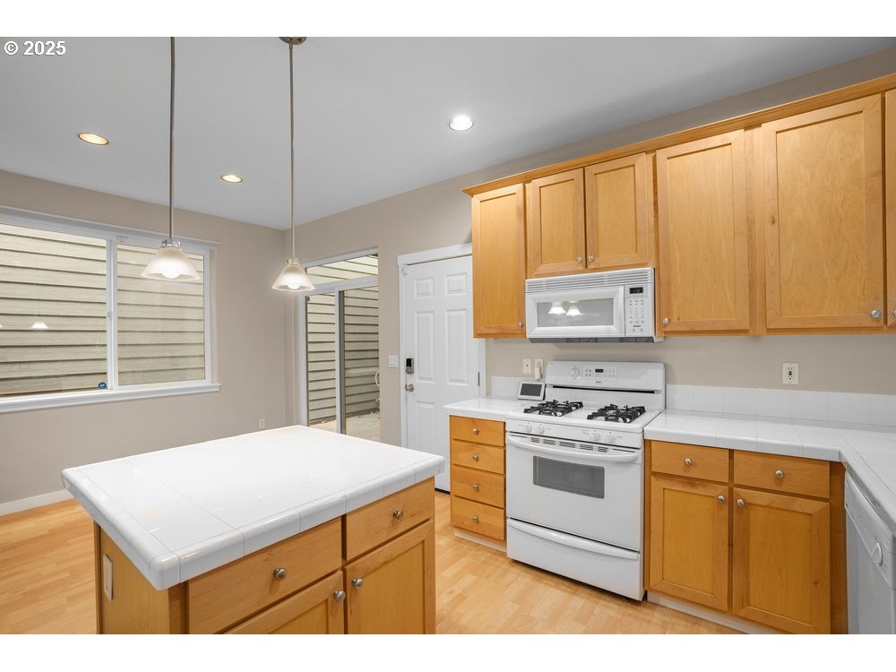 515 Northeast Suttle Street Portland, OR 97211 - Photo 5 of 28 a kitchen with a stove a sink a kitchen island with a stove a cabinets and wooden floor