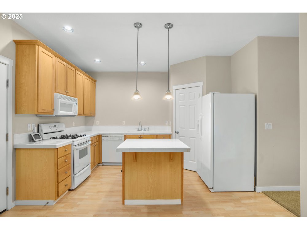 515 Northeast Suttle Street Portland, OR 97211 - Photo 8 of 28 a kitchen with kitchen island a stove a refrigerator a sink a center island and windows