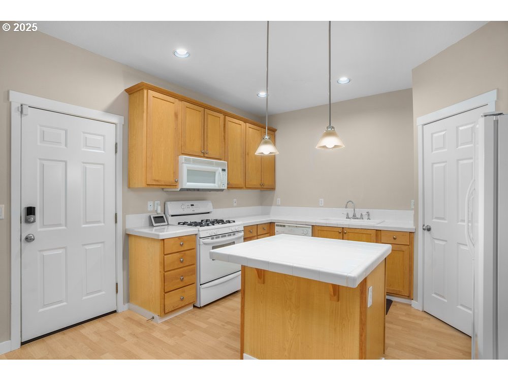 515 Northeast Suttle Street Portland, OR 97211 - Photo 9 of 28 a kitchen with stainless steel appliances granite countertop a sink a stove a refrigerator a center island and cabinets