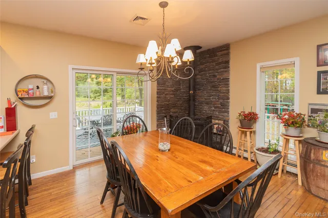 a dining room with furniture a chandelier and wooden floor