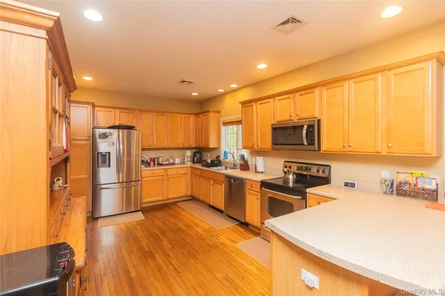 a kitchen with stainless steel appliances a refrigerator sink and microwave