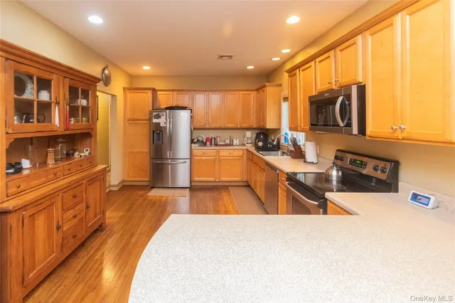 a kitchen with stainless steel appliances granite countertop a sink stove and wooden cabinets