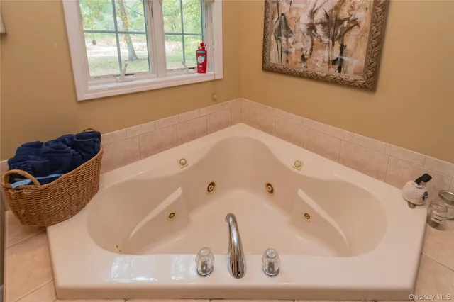 a bathroom with a tub sink and mirror
