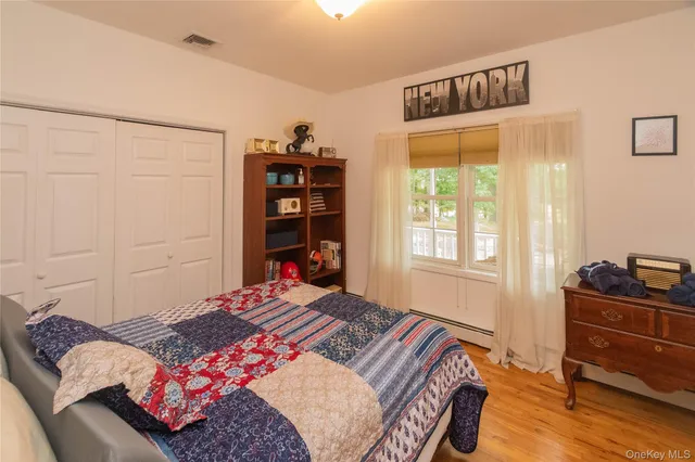 a view of a bedroom with furniture and wooden floor