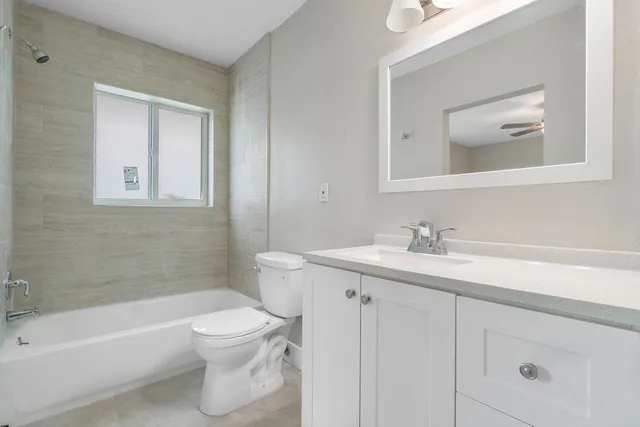 a bathroom with a toilet a sink a mirror and a bathtub