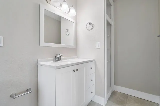 a bathroom with a sink vanity and a mirror