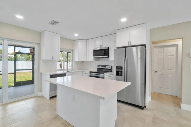 a kitchen with stainless steel appliances a refrigerator stove microwave and sink