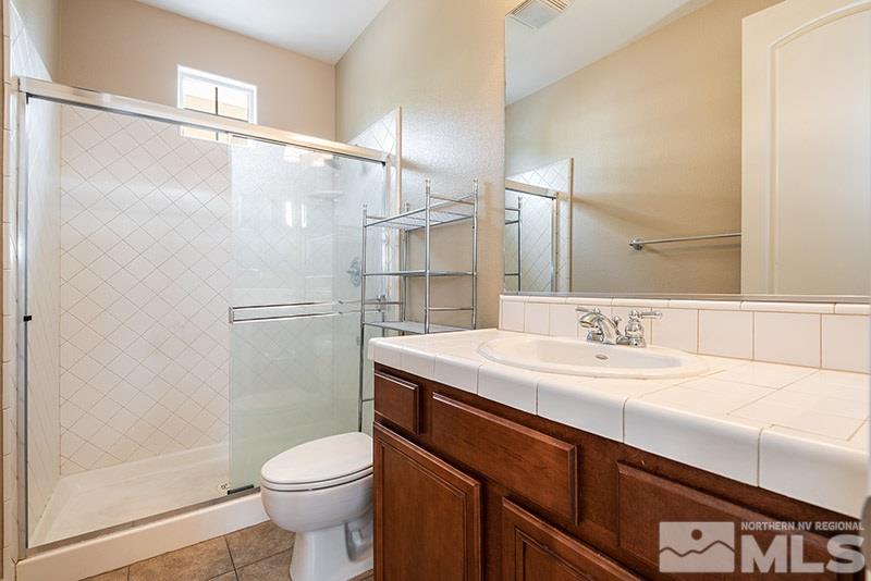 7677 Stone Bluff Way Reno, NV 89523 - Photo 11 of 17 a bathroom with a sink a toilet and shower